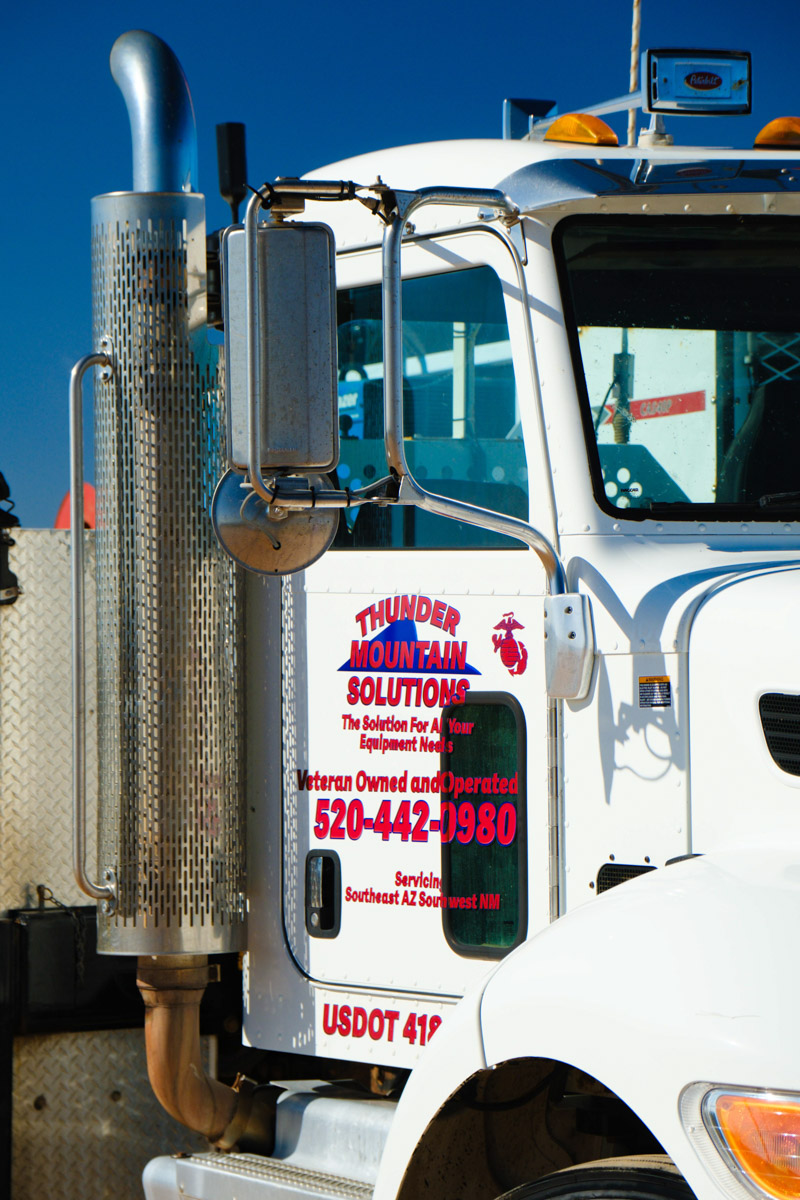 Thunder Mountain Solutions fleet — two Peterbilt service trucks with trailer